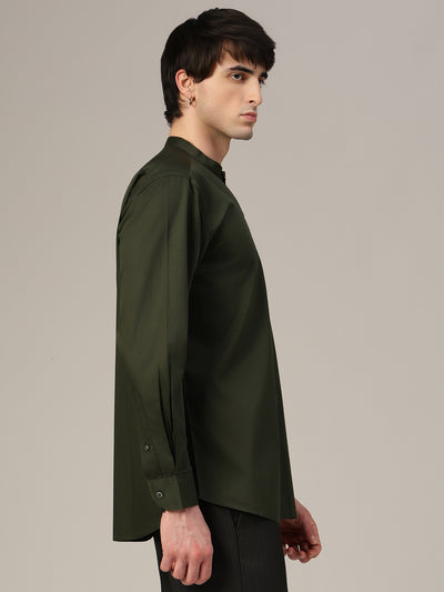 Man wearing a dark green shirt against a plain background