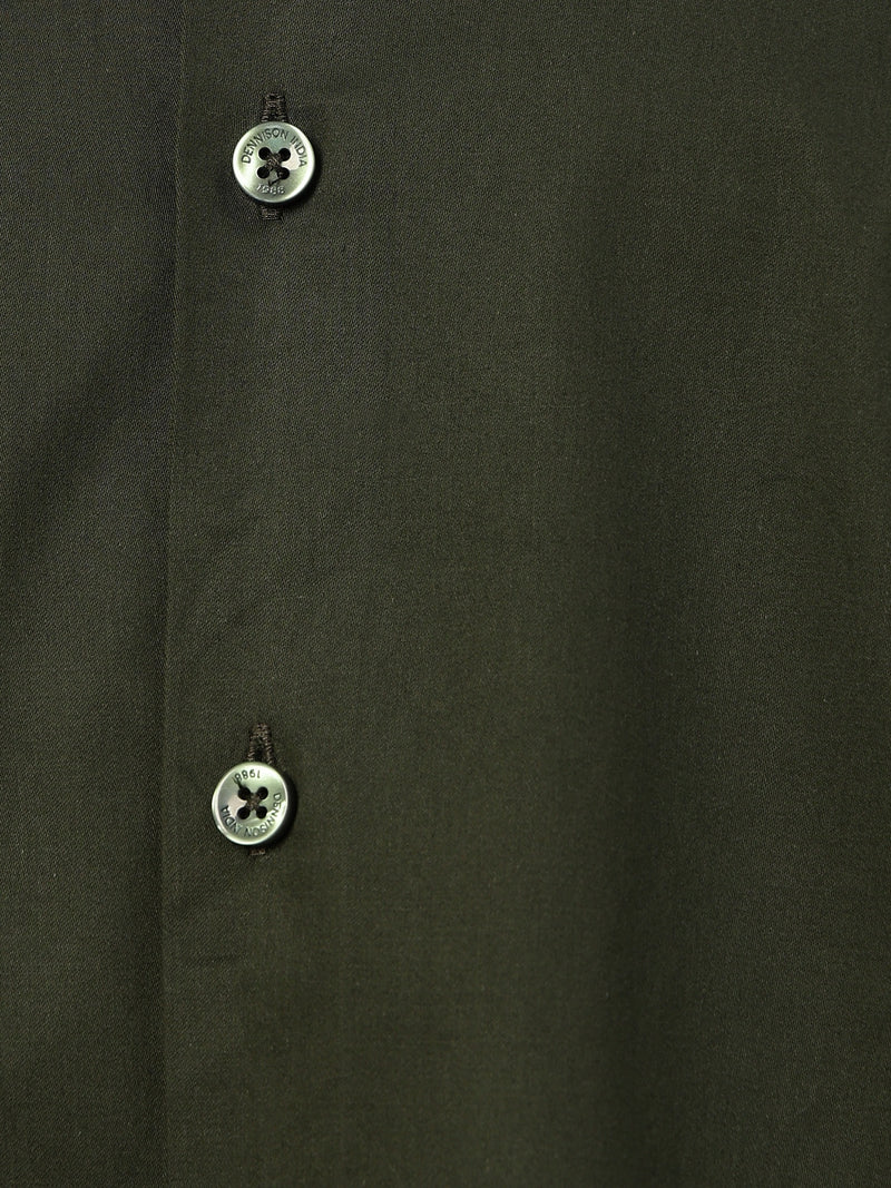 Close-up of a dark green fabric with two buttons on a plain background
