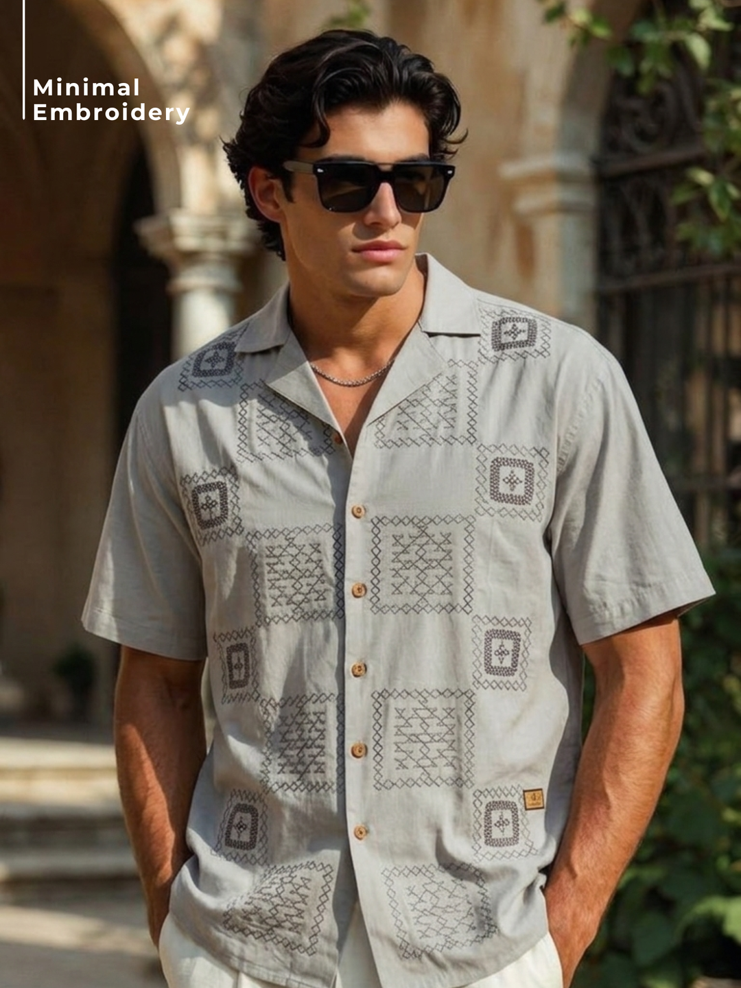 Man wearing a patterned shirt with minimal embroidery outdoors