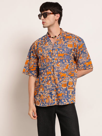 Person wearing a patterned shirt with orange and blue design on a plain background