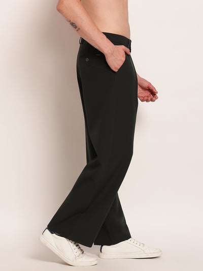 Person wearing black wide-leg pants and white sneakers on a plain background